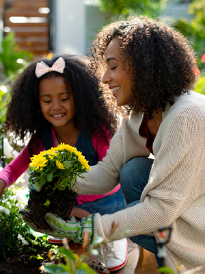 mom and daughter planting flowers