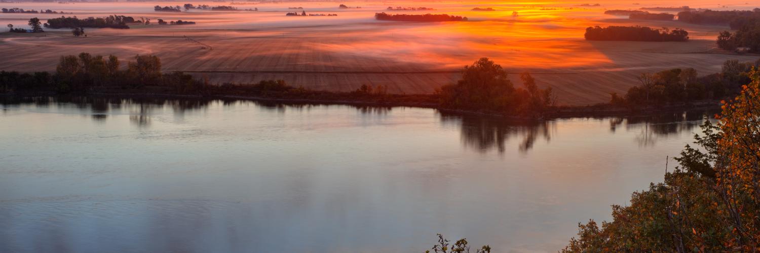 A river and farmland during a winter sunrise.