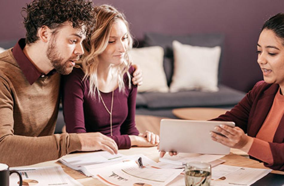 couple looking at a tablet with a businesswoman