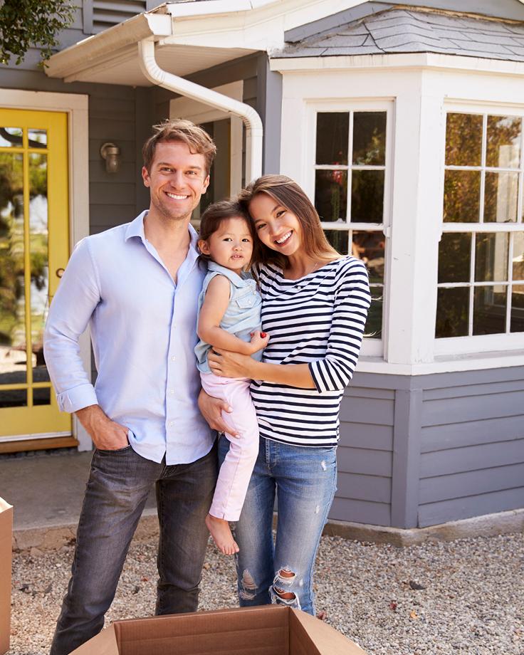 family in front of their new home