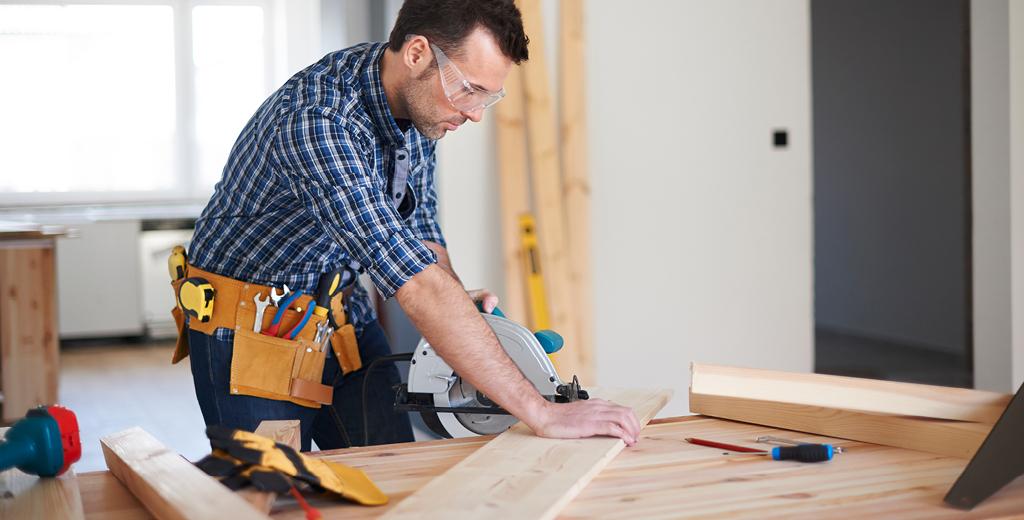 Man cutting wood with a saw.