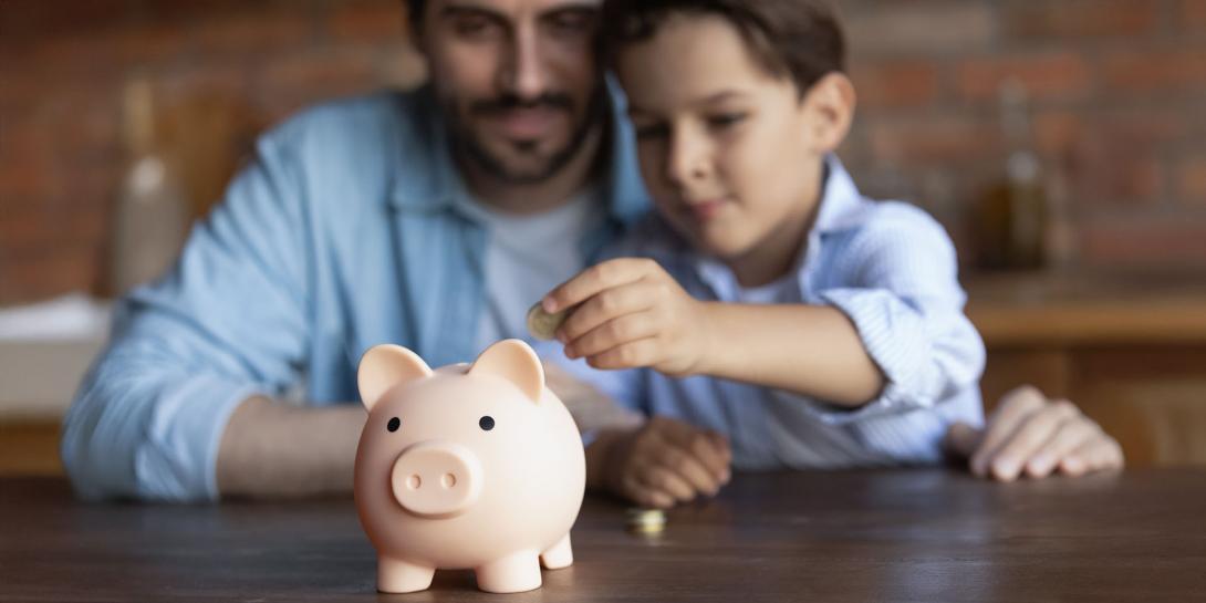 Dad and son putting money in a piggy bank